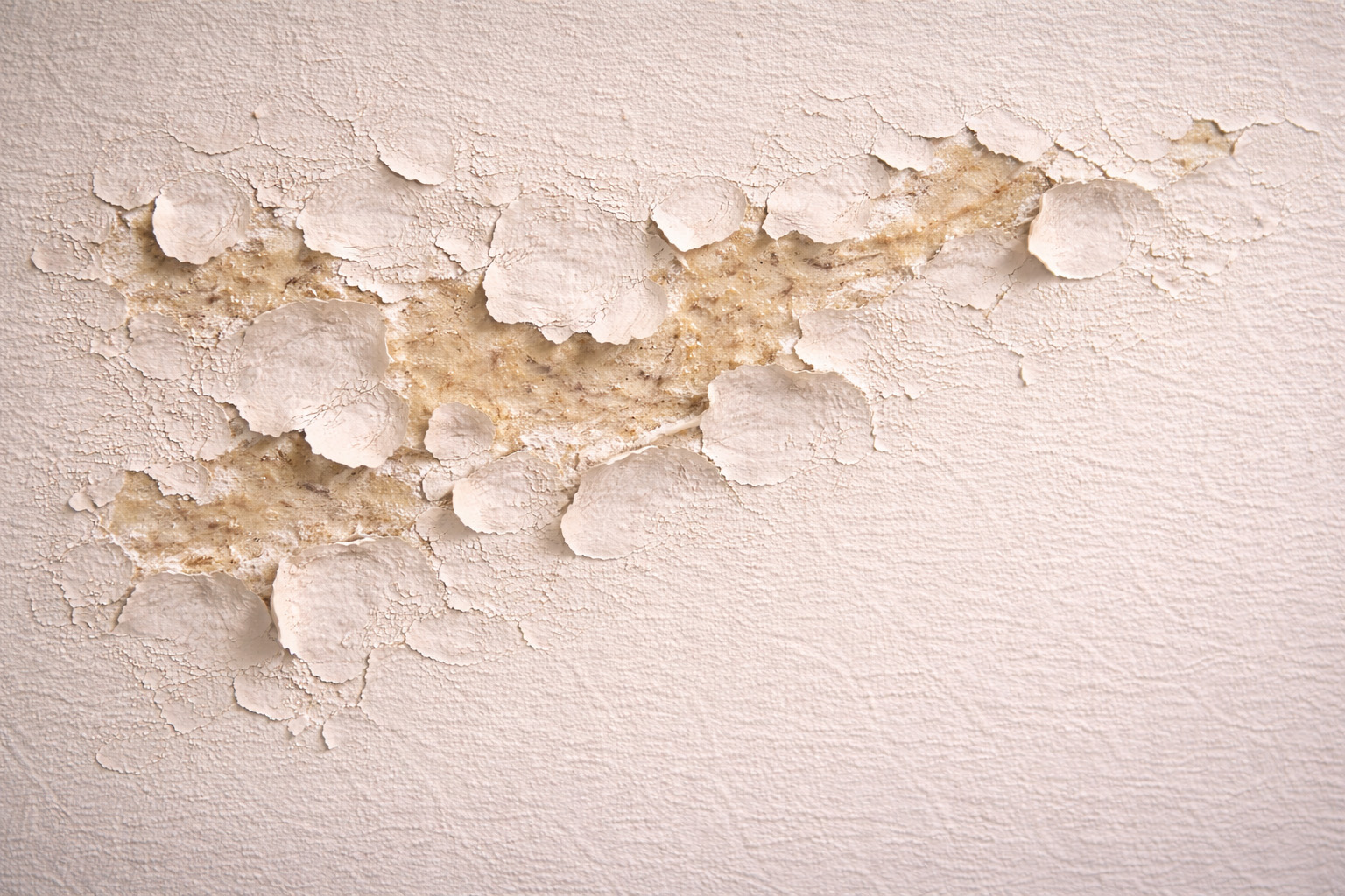 Paint failure caused by leftover adhesive after wallpaper removal